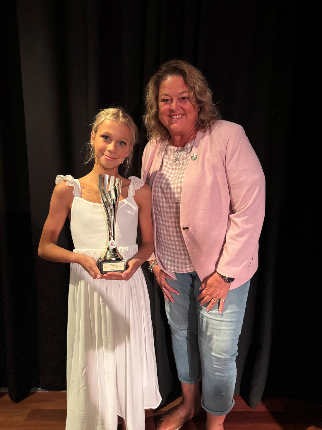 Ava standing with Minister Nat Cook